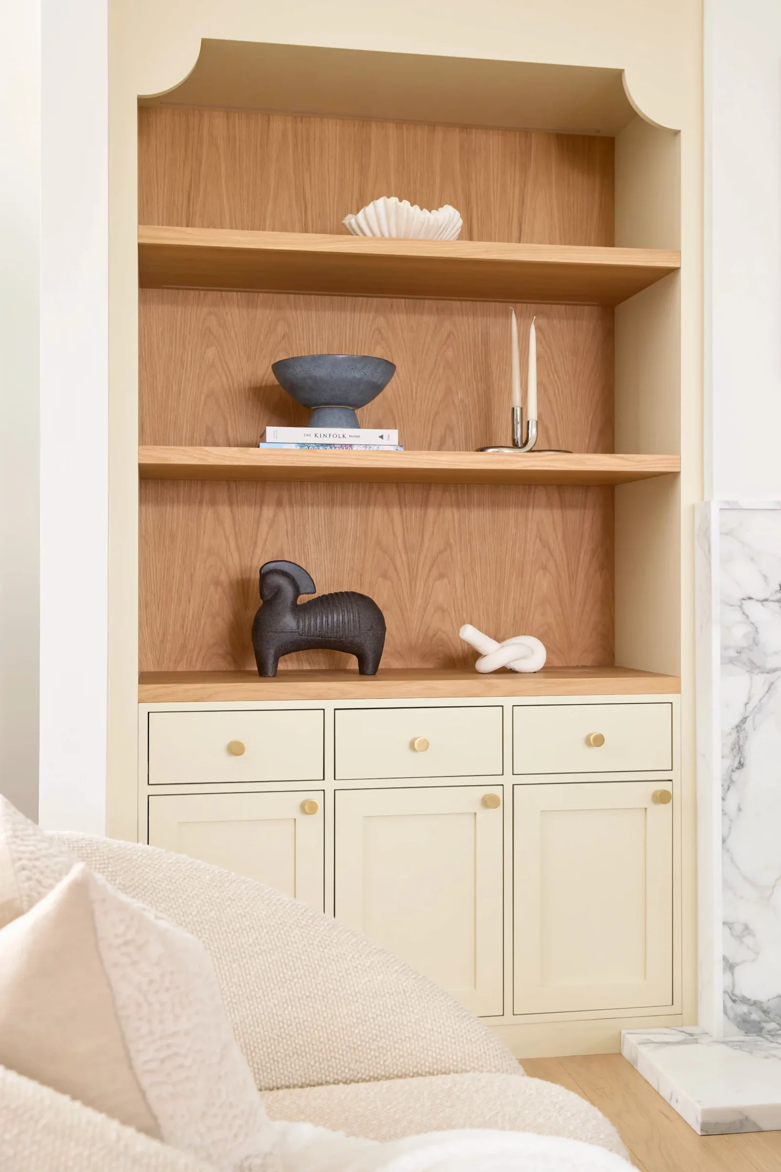 White oak open shelving above painted base cabinets with brass hardware