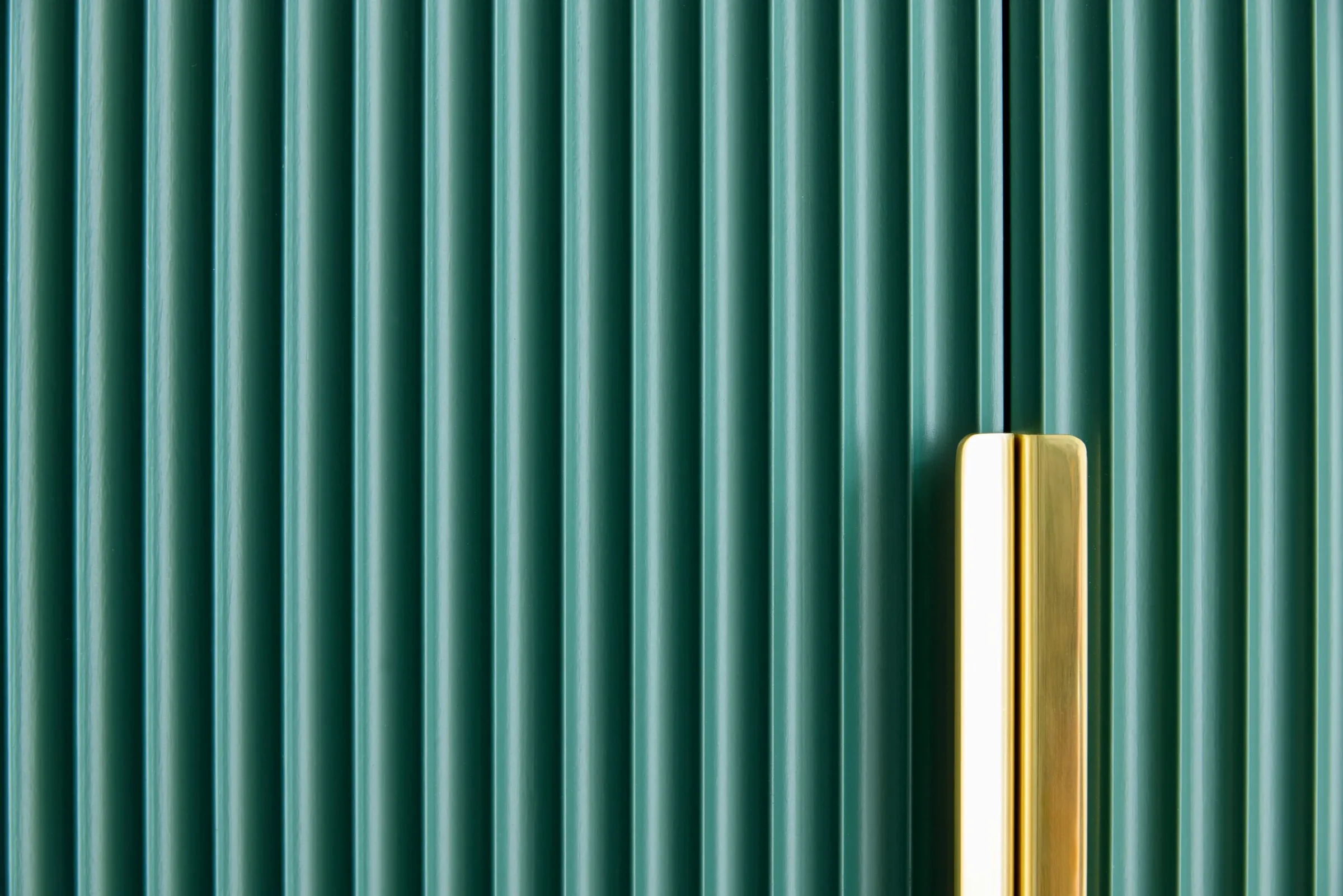 Fluted green cabinetry with a long brass pull at Quisisana, Kentfield