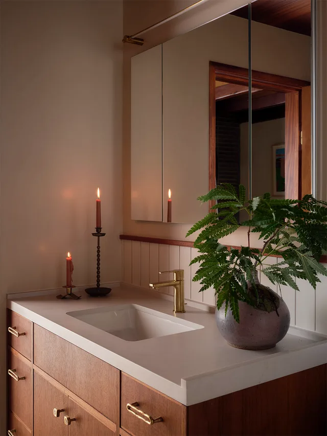 Wood vanity, stone top, and undermount basin, close
