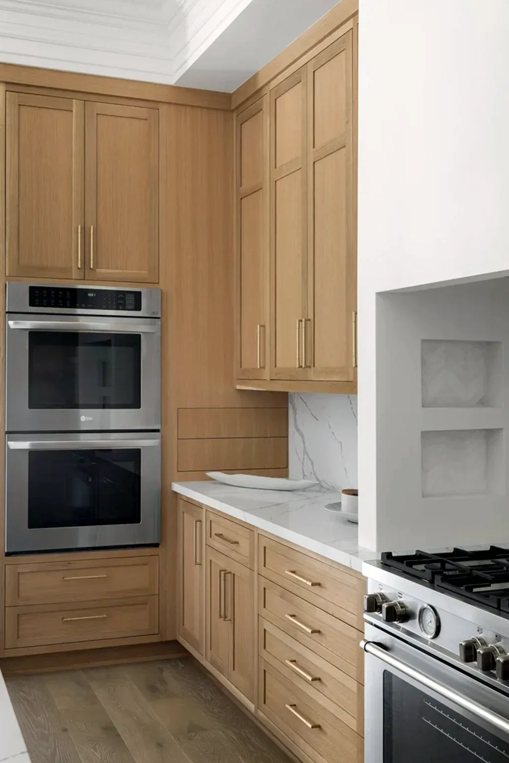Range wall with double ovens set into oak cabinetry