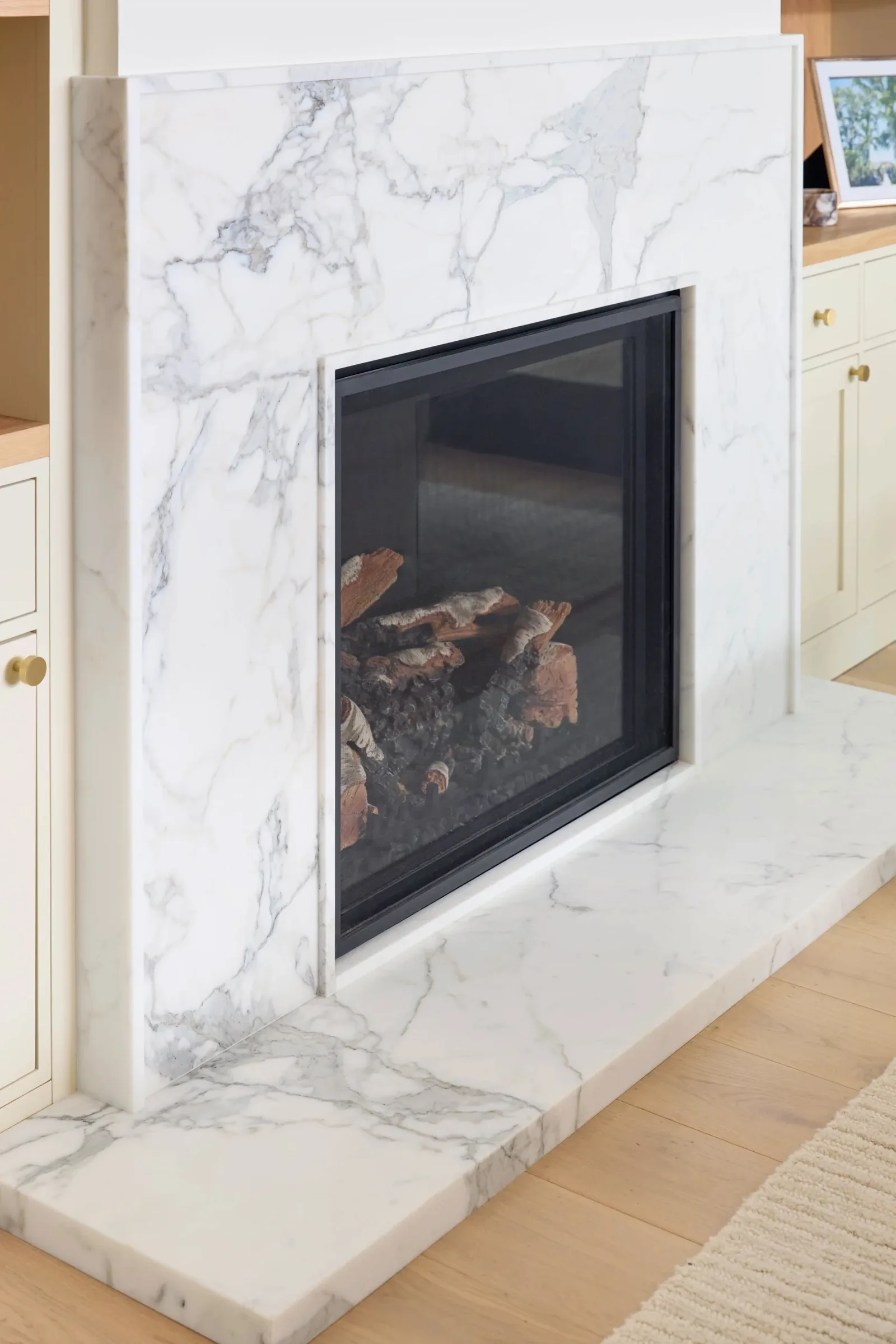 Marble fireplace surround meeting the hearth and adjoining casework