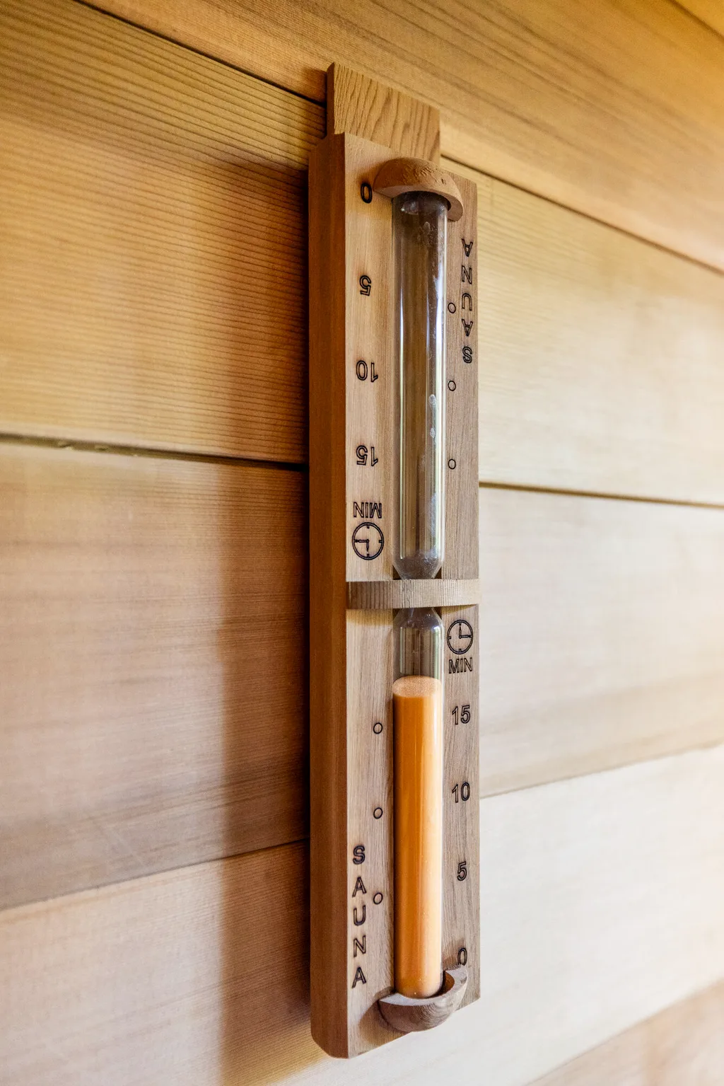 Cedar wall boards with a wall-mounted thermometer and hourglass