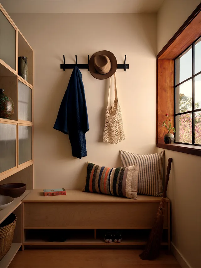 Entry bench and hooks built into a niche below a shelf