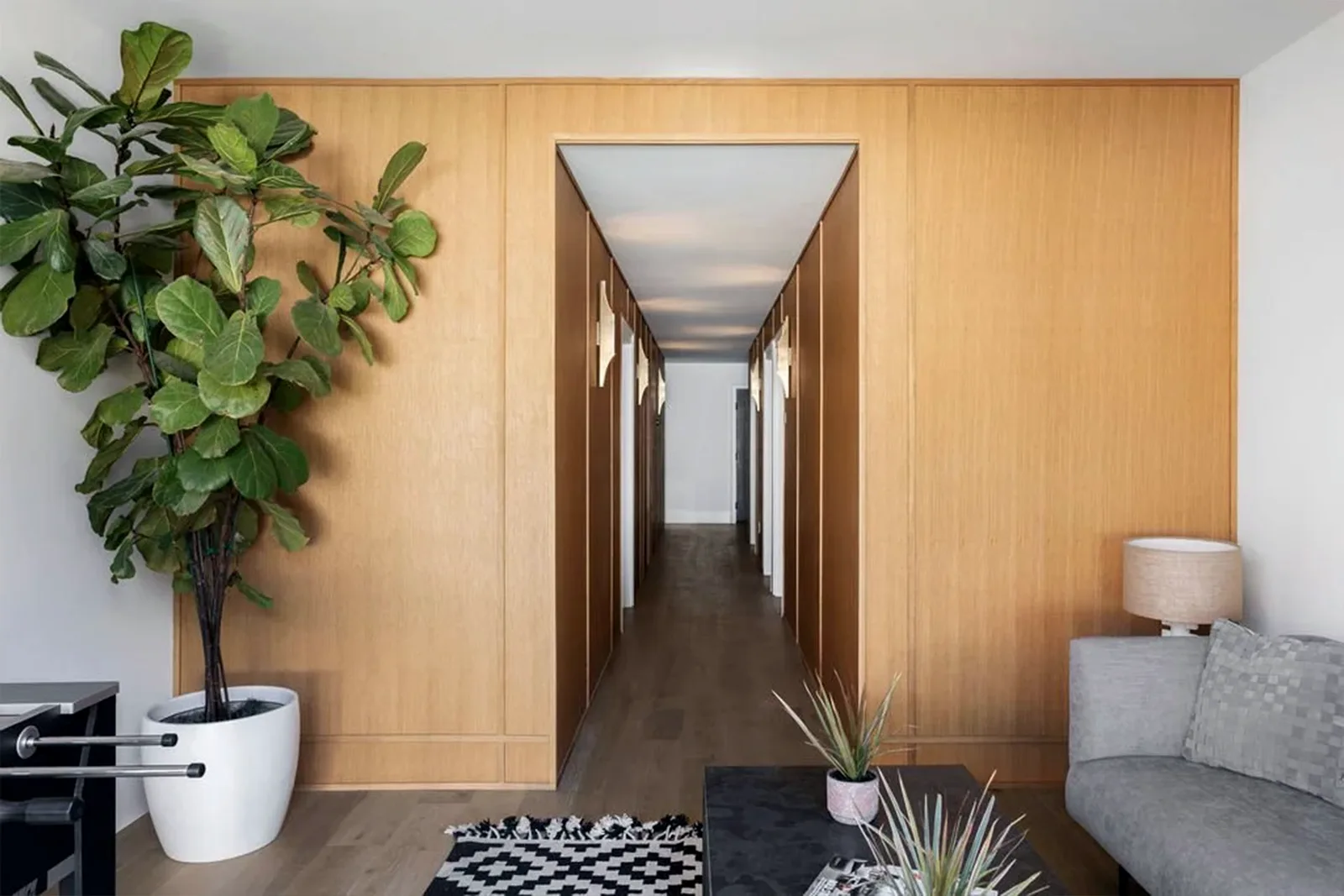Hallway lined in white oak panelling seen from the living room