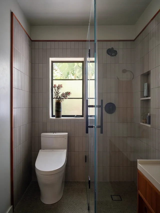 Tiled shower with a glass enclosure and a small window