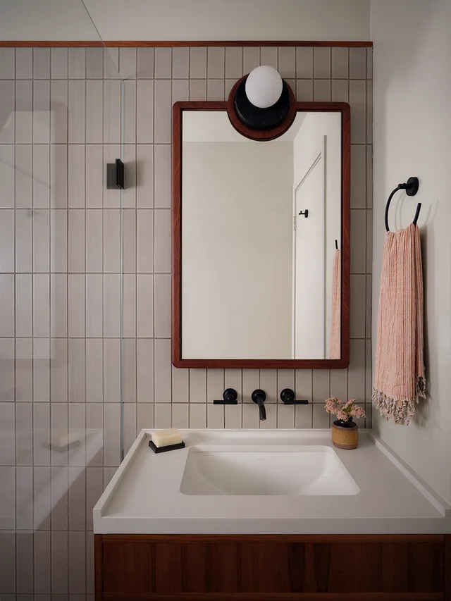 Bath vanity and tub deck with a wood-framed mirror