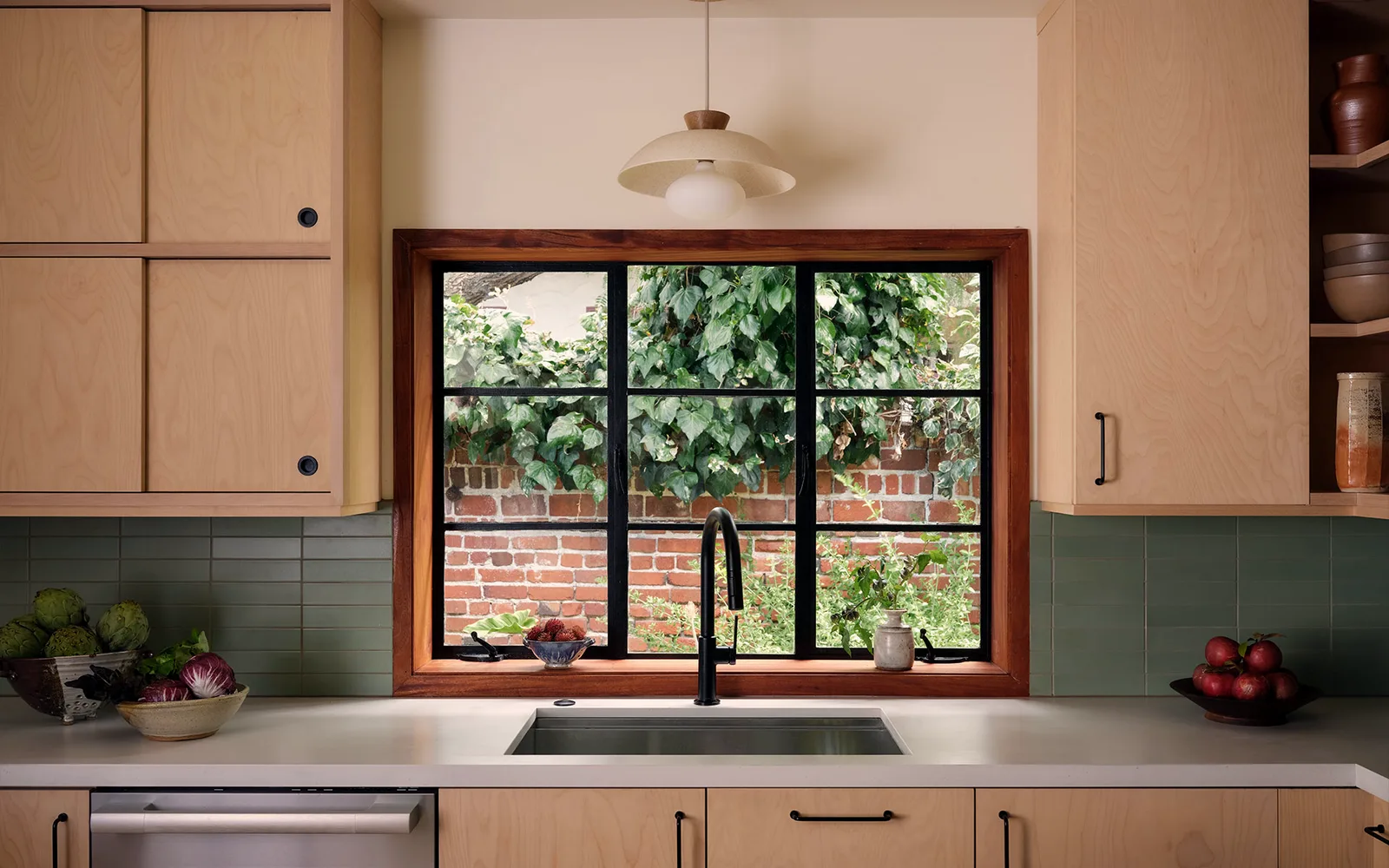 Kitchen sink run beneath a steel-framed window onto the garden