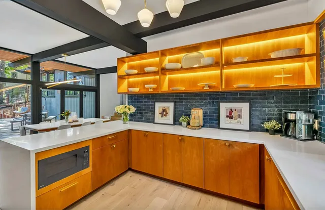 Kitchen run with lit open shelving above the counter
