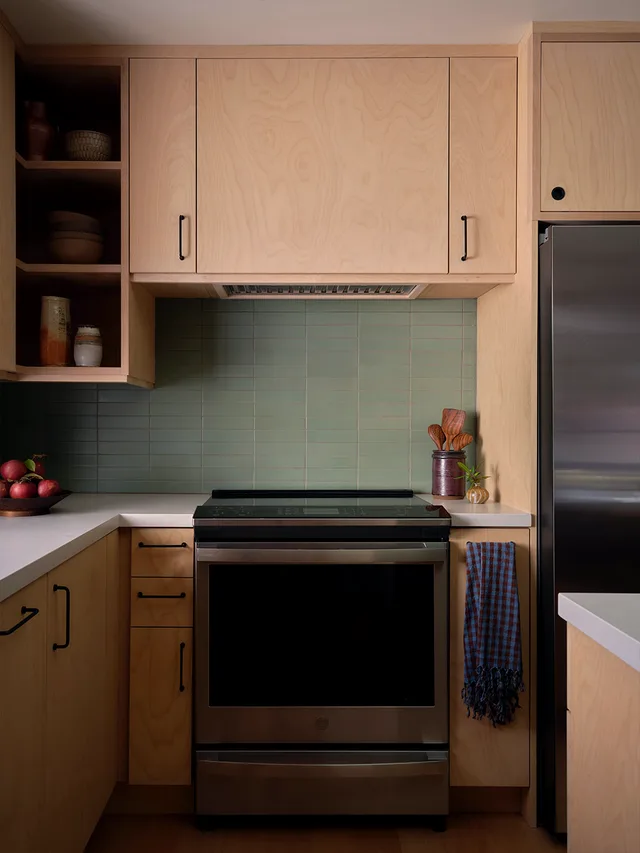 Range wall with maple cabinetry and a green tile backsplash