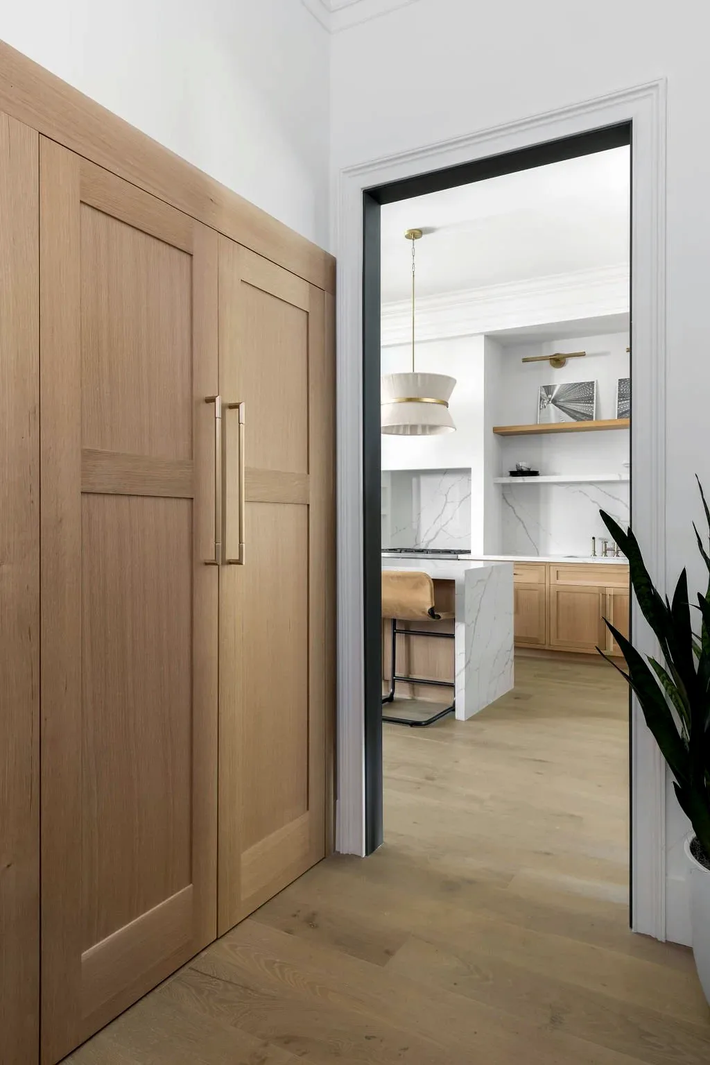 Full-height oak door standing open to the kitchen beyond