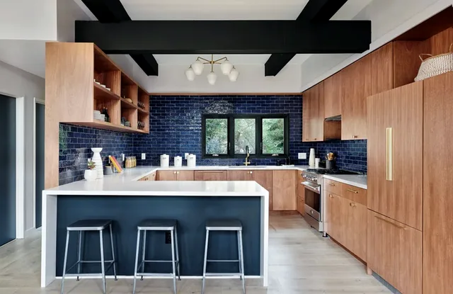 Kitchen island with counter stools and a deep blue tile backsplash